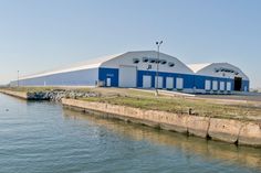 an industrial building sits next to the water