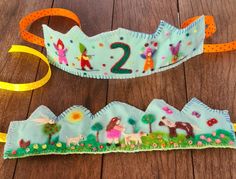 two children's headbands made out of fabric with numbers and animals on them