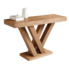 a wooden table with a white vase and some books on the top, against a white background