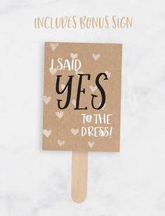 a sign that says i said yes to the dress on a wooden stick with hearts