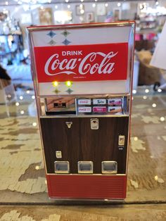 a coca - cola machine sitting on top of a counter