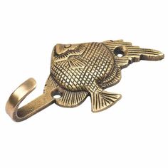 an antique brass fish shaped ring on a white background with clippings to the side