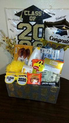 a graduation gift basket with condiments and snacks on a table in front of a sign that reads class of 20