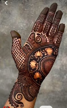 a woman's hand with henna tattoos on it