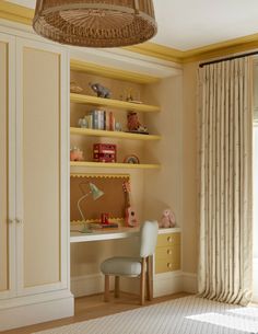 a bedroom with yellow walls and shelves filled with books, toys, and other items