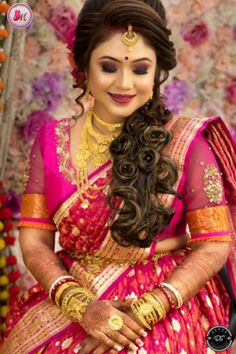 a woman in a pink and gold sari