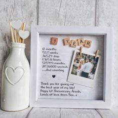 a photo frame with the words i love you in scrabble letters next to a vase