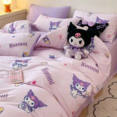 a bed with pink and purple comforters, pillows and stuffed animals on it in a bedroom