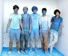 five young men standing in a room with blue paint all over their face and body