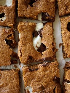 chocolate chip cookie bars cut into squares and arranged on top of each other with white frosting