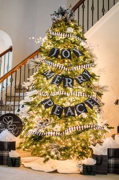 a christmas tree decorated with black and white ribbon