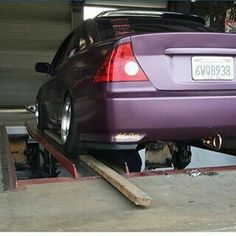 the back end of a purple car parked in a garage