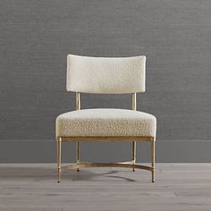 a white chair sitting on top of a hard wood floor next to a gray wall