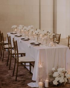 a long table is set with white flowers and candles for an elegant wedding reception at the four seasons hotel