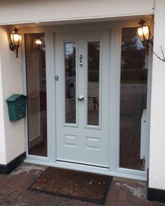 a white double door with two sidelights on the front of a house in england