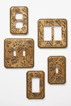 three decorative switch plates with floral designs on the front and one in the back, all made out of wood