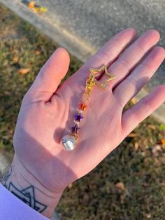 a person's hand with a star and beaded bracelet on it