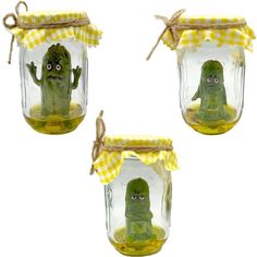 three glass jars filled with green items on top of a white surface