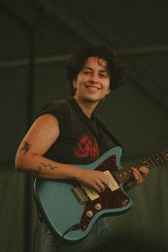 a young man playing an electric guitar on stage