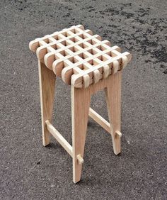 a stool made out of wooden pegs sitting on the ground