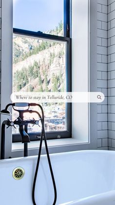 a white bath tub sitting under a window next to a wall mounted faucet