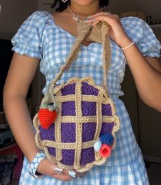 a woman is holding a crocheted purse with hearts on the front and sides