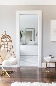 a white room with a chair and mirror