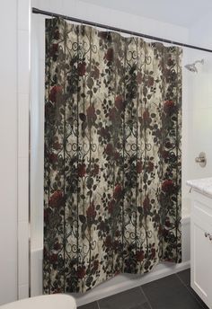 a bathroom with a shower curtain that has red flowers on it