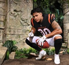 a man kneeling down with a football in his hand