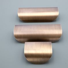 two metal brackets on a gray wall