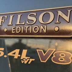 a close up of a metal sign on the side of a vehicle that says filson