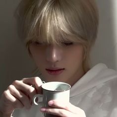 a woman with blonde hair holding a coffee cup