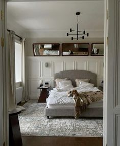 a dog is sitting on the bed in this bedroom