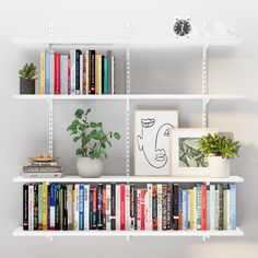 a bookshelf filled with lots of books next to a potted plant