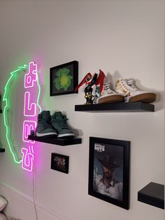 there is a neon sign on the wall next to shoes and framed pictures hanging on the wall