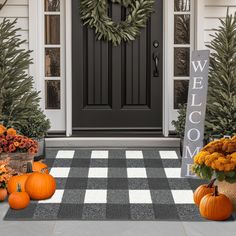 a front porch decorated for fall with pumpkins and flowers