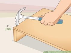 a hand holding a wrench over a wooden table with measurements on the bottom and sides