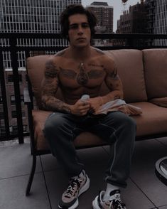 a man with tattoos sitting on a bench