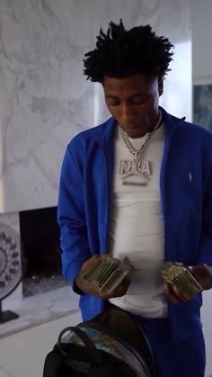 a man in a blue jacket holding some gold coins