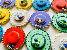 there are many decorated cookies on the table with different colors and designs, including hats