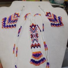 This Beautiful Native American Beaded Necklace and Earring Set is made by Elaine out of White, Orange, Hot Pink and Dark Purple Delica Beads. Multicolor Southwestern Beaded Necklace With Dangling Beads, Southwestern Style White Beaded Necklace With Large Beads, Southwestern Style White Jewelry With Dangling Beads, Southwestern Large Beads For Crafting, Southwestern Style Large White Beads, White Southwestern Hand-strung Beaded Necklace, White Southwestern Beaded Necklace, Southwestern White Hand-strung Beaded Necklace, Southwestern White Beaded Necklaces For Festivals