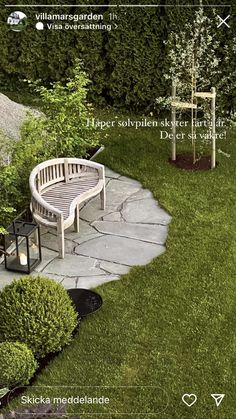 a bench sitting in the middle of a lush green yard next to a stone path