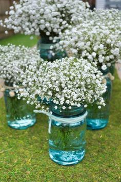 four mason jars filled with baby's breath flowers