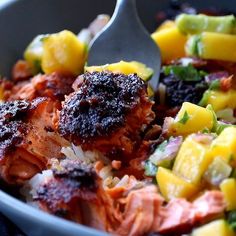 a bowl filled with meat, rice and fruit