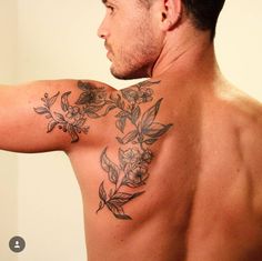 a man with a flower tattoo on his upper arm and shoulder is taking a selfie