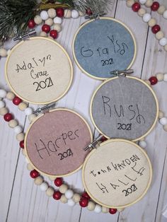 four embroidery hoops with the names of each year on them and some decorations around them