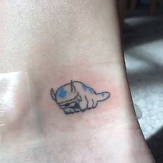 a small tattoo on the ankle of a person with a dog in it's paw