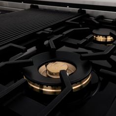 a close up view of the burners on a gas stove with black and gold trim