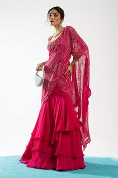 Fuchsia pink pre-draped tiered lehenga saree with circular motifs embroidered in pearls and sequins. Comes with embroidered blouse.
Component: 2
Pattern: Embroidery
Type Of Work: Pearls, Sequins
Sleeve Type: Sleeveless
Fabric: Blouse: Tussar, Saree: Organza and Chiffon
Color: Fuchsia
Other Details: 
Ruffle detailing
Note: The bag shown in the images is not for sale
Occasion: Destination Wedding - Aza Fashions Tiered Lehenga, Saree Organza, Tussar Saree, Ruffle Saree, Drape Saree, Sequin Sleeve, Lehenga Saree, Color Fuchsia, Pattern Embroidery