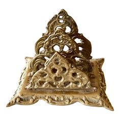 an ornately designed gold metal object on a white background